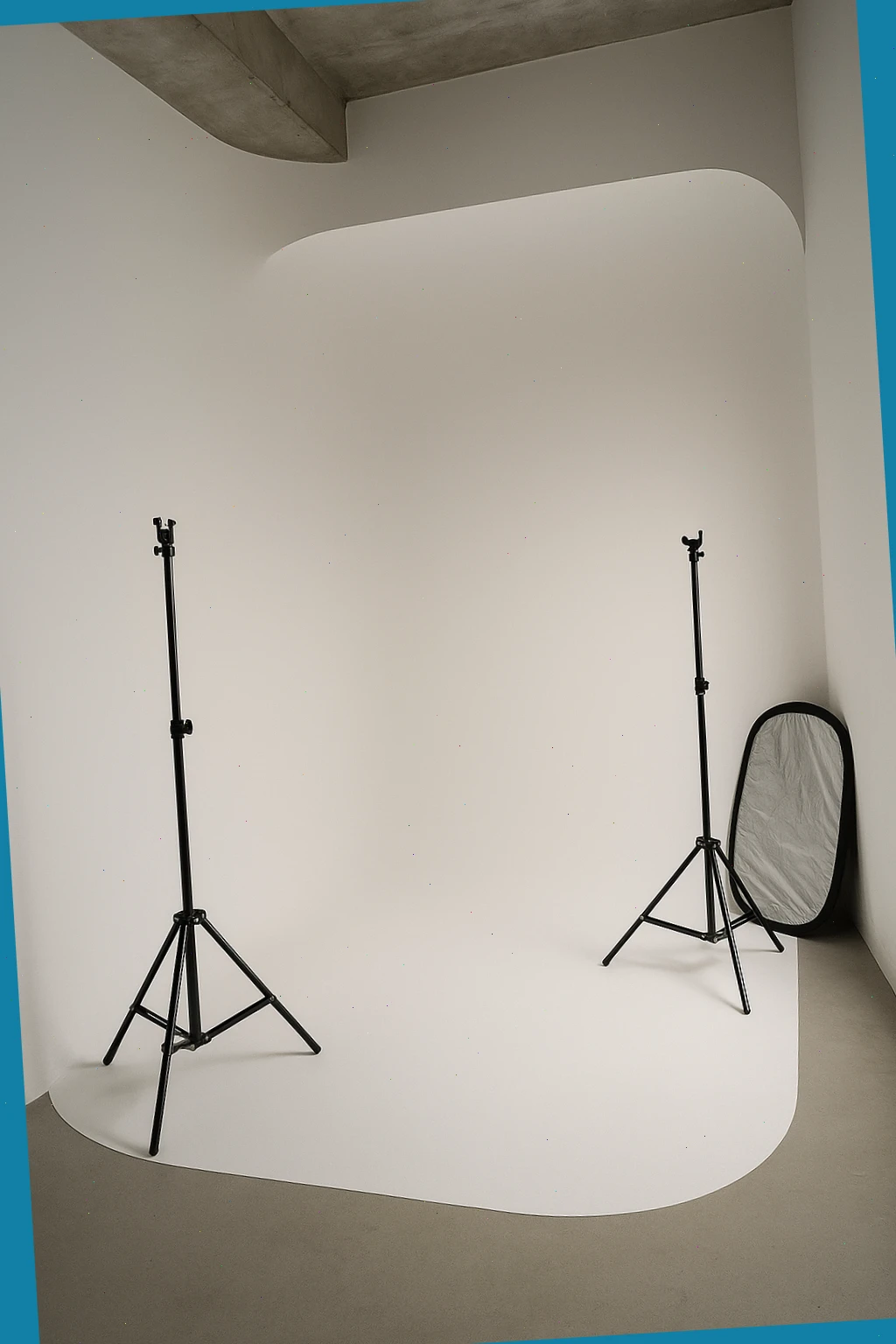 compact cyclorama with two light stands and a folded reflector ready for setup